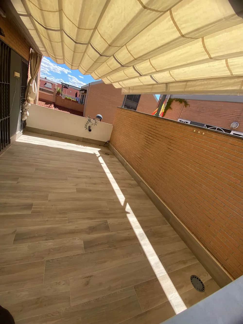 Terraza terminada con toldo y suelo imitación madera
